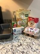 面粉的图片, 个装鸡蛋的盒子, 糖, 黄油, 生姜, 玫瑰水, 灰色斑点的柜台上放着一个面包盘.