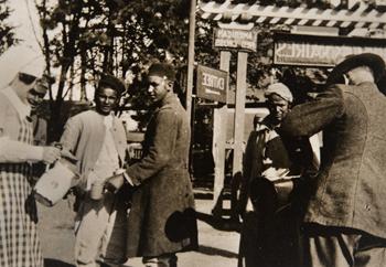 Red Cross workers offering beverages to soldiers outside a canteen Photograph